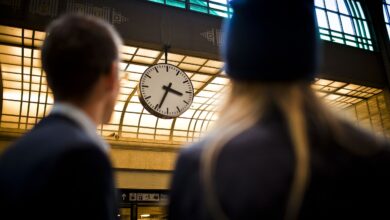 Zmiana Czasu zegar o sylwetki dwóch osób na dworcu kolejowym