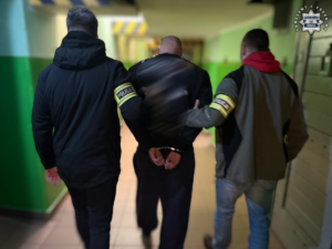 Kryminalni zatrzymali 30-latka z kilogramem amfetaminy Policjanci prowadzą zatrzymanego męzczyzne