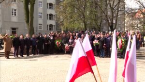 Katowice uczciły 85. rocznicę Zbrodni Katyńskiej, na pierwszym planie flagi, na drugim grupa osób