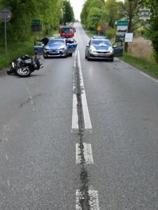 wypadek motocyklisty Ciągowice, na drodze przewrócony motocykl dwa radiowozy i wóz straży pożarnej