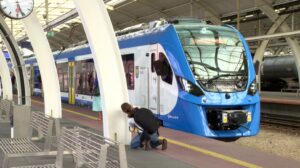 Nowoczesne, wygodne i w pełni elektryczne – Koleje Śląskie właśnie zyskały nowe składy! W środę, 31 lipca 2025 roku, na stacji w Gliwicach zaprezentowano dwa nowe pociągi Impuls 2, które już niebawem ruszą w trasę z pasażerami. Nowe pociągi Kolei Śląskich już gotowe To część ogromnego projektu wartego blisko miliard złotych, finansowanego z programu „Fundusze Europejskie dla Śląskiego”. Łącznie na tory województwa śląskiego trafią aż 26 nowoczesnych Impulsów 2, a dołączą one do pięciu składów zamówionych bezpośrednio przez przewoźnika. Flota Kolei Śląskich zwiększy się tym samym o połowę! – Nowe pociągi oznaczają większy komfort podróżowania i zachętę, by zrezygnować z samochodu na rzecz kolei – podkreślił podczas prezentacji w Gliwicach Grzegorz Boski, wicemarszałek Województwa Śląskiego. Komfort i technologia na pierwszym planie Nowe czteroczłonowe pociągi Impuls 2 rozwijają prędkość do 160 km/h. Na pokładzie znalazło się 400 miejsc dla pasażerów, w tym 192 siedzące. Nie zabrakło także: stref dla rodzin z dziećmi, przestrzeni na 10 rowerów, udogodnień dla osób z niepełnosprawnościami, nowoczesnego systemu informacji pasażerskiej w trzech językach. To wszystko przy energooszczędnym oświetleniu LED i ekologicznej technologii napędu. Więcej pociągów jeszcze w tym roku Już w sierpniu i wrześniu na tory wyjadą kolejne cztery składy zamówione przez województwo, a w grudniu dołączą do nich jeszcze dwa z zamówienia Kolei Śląskich. W sumie kontrakty zawarte z firmą Newag z Nowego Sącza opiewają na 31 składów o łącznej wartości 1,5 miliarda złotych (wraz z serwisem technicznym). – To największa inwestycja taborowa w historii spółki. Dziękujemy pasażerom za zaufanie – zaznaczył Krzysztof Klimosz, prezes Kolei Śląskich - Impuls 2 przód pociągu