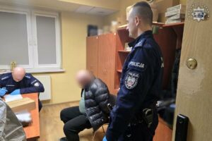 zabójstwo duchownego Kłobuck - zatrzymany mężczyzna siedzi na krześle obok policjant